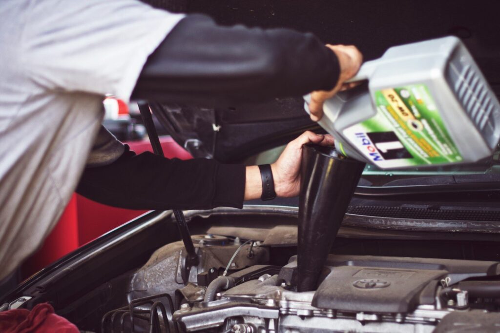 Best 5W-30 Motor Oil man refilling motor oil on car engine bay
