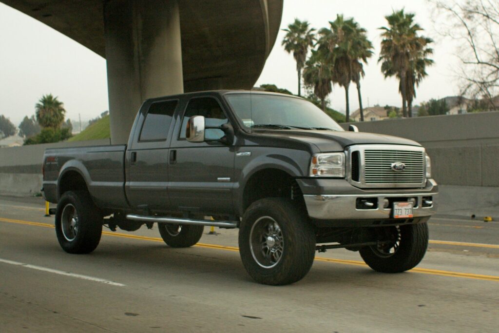 Best 5 Tonneau Covers for Ford F-350 A dark gray pickup truck driving on a highway.